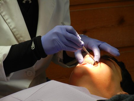 Person performing orthodontics in Glasgow on a young man
