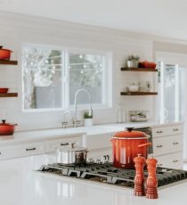 white modern kitchen with blood orange pots and utensils