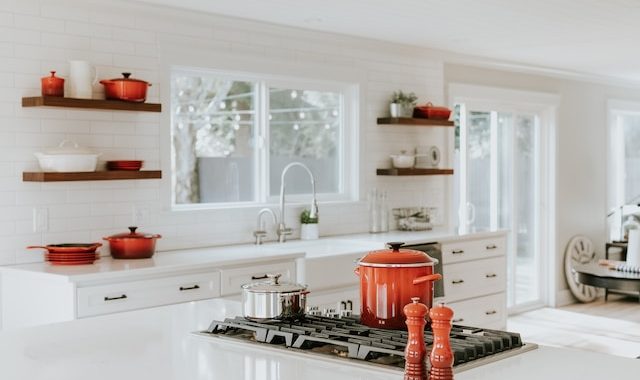 white modern kitchen with blood orange pots and utensils